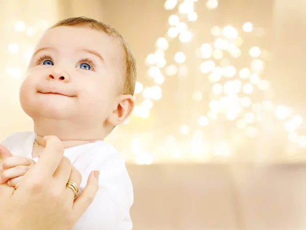 Close up de bebê doce sobre luzes de Natal — Fotografia de Stock
