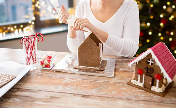 Vrouw Peperkoekhuisjes maken op Kerstmis — Stockfoto