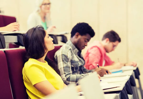 Group of students with notebooks in lecture hall — Stock Photo, Image