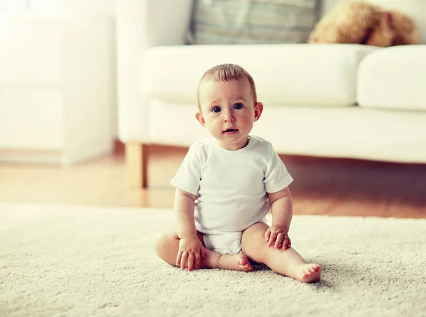 幸せな男の子か女の子が家の床に座って — ストック写真