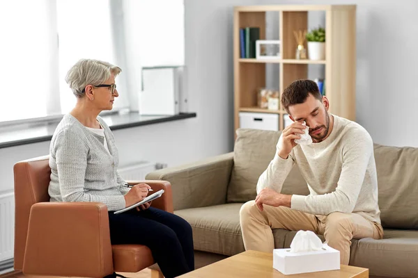 Senior vrouw psycholoog en huilen man patiënt — Stockfoto