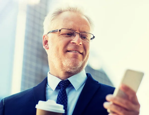 Businessman with smartphone and coffee in city — Stock Photo, Image