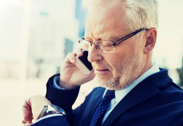 Senior zakenman belt op smartphone in de stad — Stockfoto