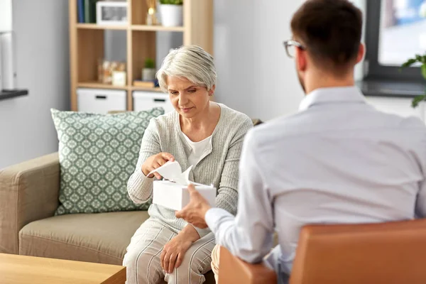 Psycholoog geven weefsels aan senior vrouw cliënt — Stockfoto