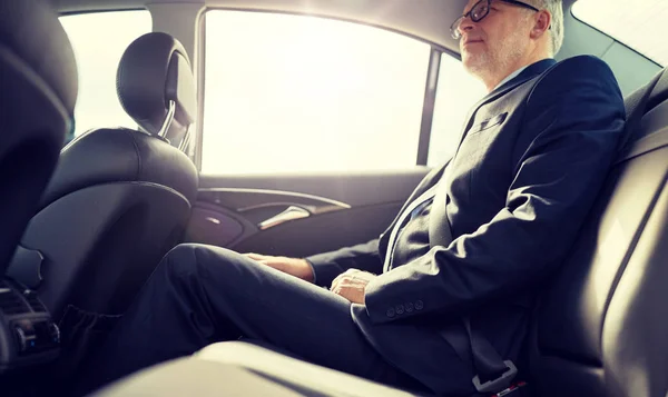 Hombre de negocios senior conduciendo en el asiento trasero del coche —  Fotos de Stock