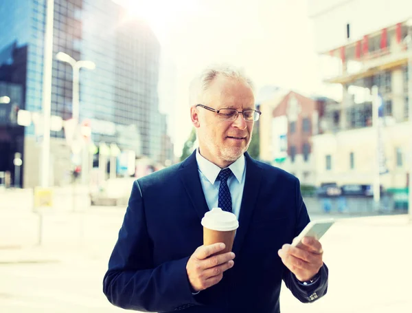 Üzletember-a smartphone és a kávé, a város — Stock Fotó