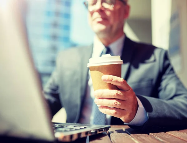 Senior affärsman med bärbar dator och kaffe utomhus — Stockfoto