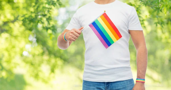Hombre con bandera de arco iris y pulseras de orgullo gay — Foto de Stock