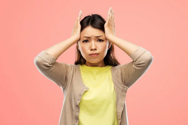 Stressad asiatisk kvinna håller fast vid huvudet — Stockfoto