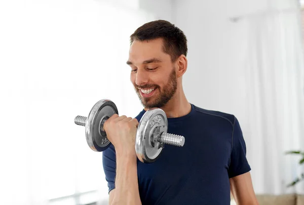 Man exercising with dumbbell at home — Stock Photo, Image