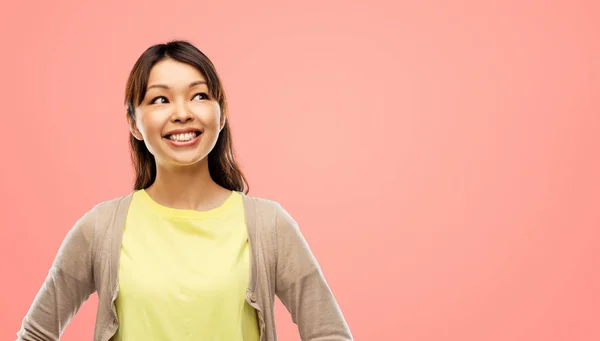 Feliz asiático mujer buscando encima gris fondo — Foto de Stock