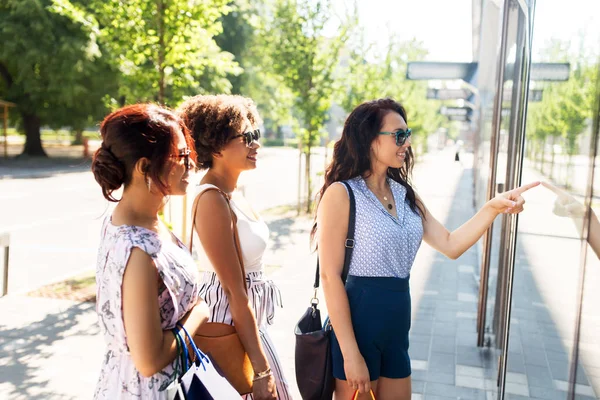 Mulheres com sacos de compras olhando para a vitrine da loja — Fotografia de Stock