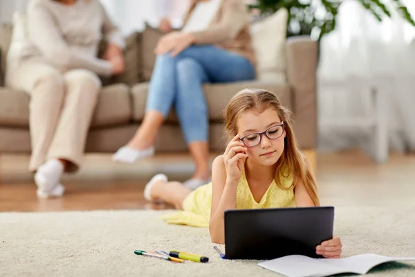 Student flicka med surfplatta ligger på golvet hemma — Stockfoto