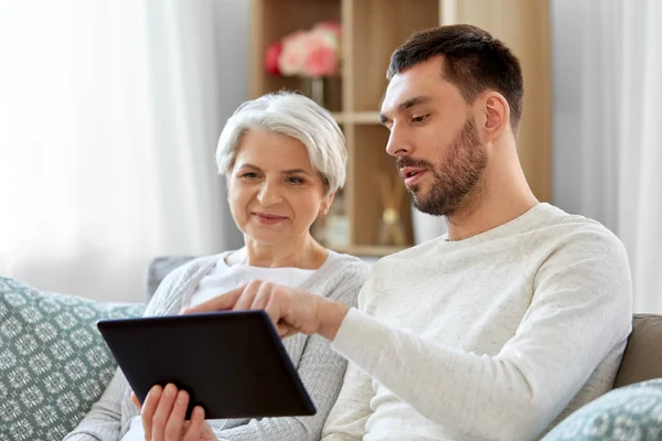 Alte Mutter und erwachsener Sohn mit Tablet-PC zu Hause — Stockfoto