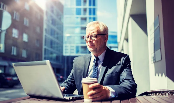 Senior businessman with laptop drinking coffee — Stock Photo, Image