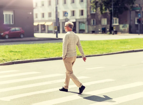 Uomo anziano a piedi lungo il passaggio pedonale della città — Foto Stock