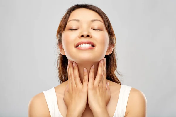 Felice sorridente giovane donna asiatica toccare il suo volto — Foto Stock
