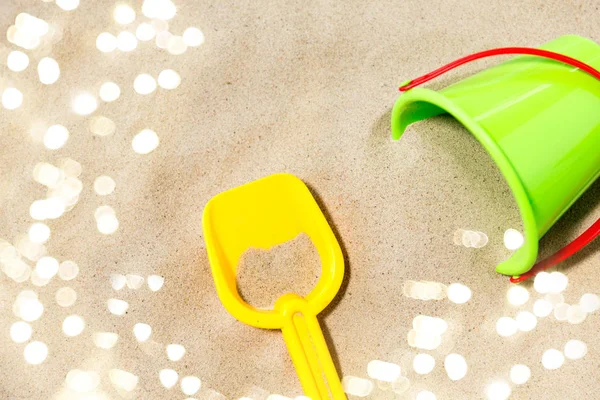 Zbliżenie wiadra zabawek i łopaty na piasku plaży — Zdjęcie stockowe