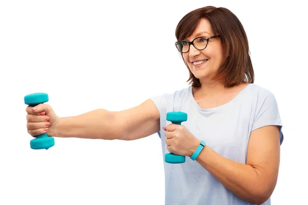 Sorrindo mulher idosa com halteres exercendo — Fotografia de Stock