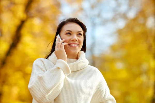 Frau ruft im Herbstpark mit Smartphone an — Stockfoto