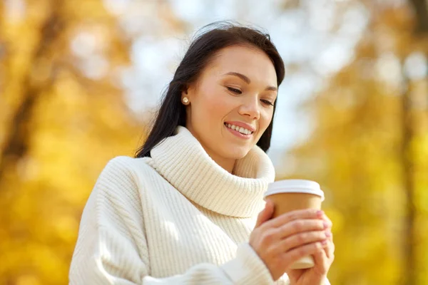 Kvinna dricka hämtmat kaffe i höstparken — Stockfoto