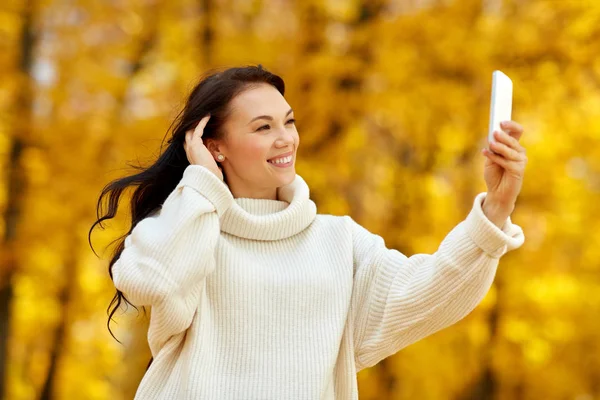 Žena brát selfie smartphone v podzimním parku — Stock fotografie
