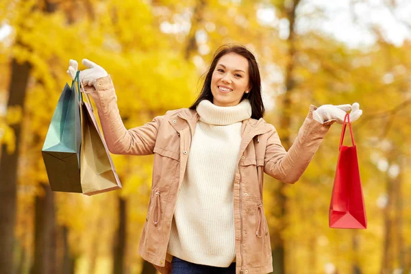 Kvinna med shoppingväskor i höstparken — Stockfoto