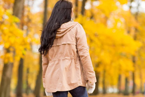 Ung kvinna promenader i höstparken — Stockfoto
