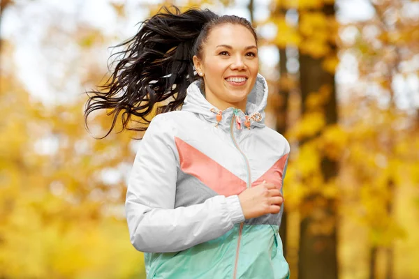 Jeune femme courant dans le parc d'automne — Photo