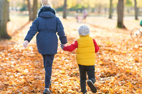 Happy children running at autumn park — Stock Photo, Image