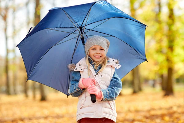 Счастливая маленькая девочка с пупсом в осеннем парке — стоковое фото