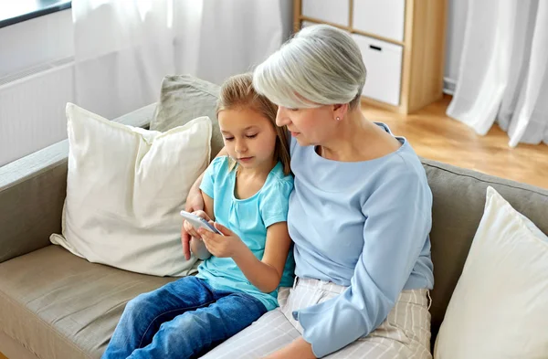 Grandmother and granddaughter with smartphone — Stock Photo, Image