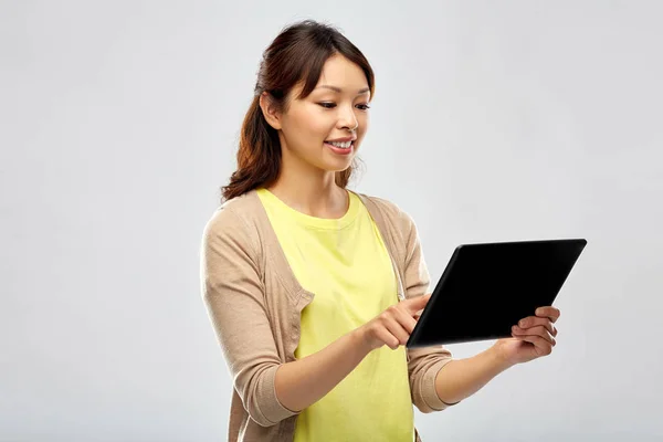 Счастливая азиатка с помощью планшетного компьютера — стоковое фото