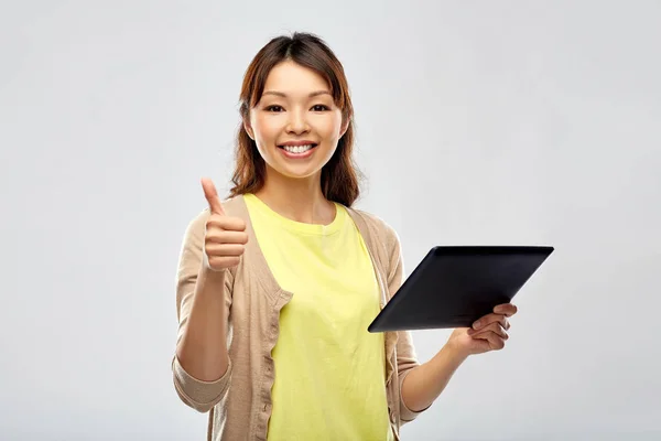 Tablet bilgisayar kullanan mutlu Asyalı kadın — Stok fotoğraf