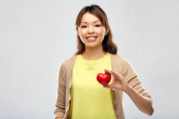 Happy asian woman holding red heart — Stock Photo, Image
