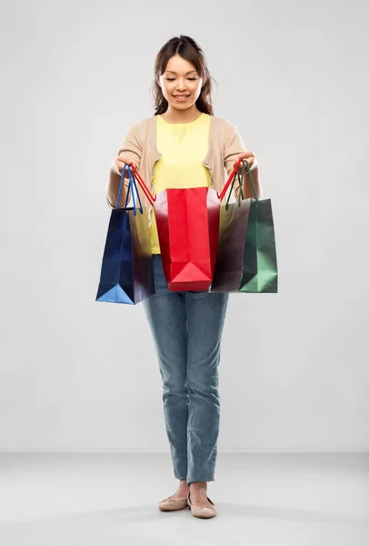 Счастливая азиатка с сумками для покупок — стоковое фото