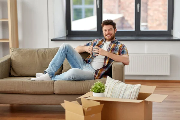 Mann mit Schachteln und Kaffeetrinken im neuen Zuhause — Stockfoto