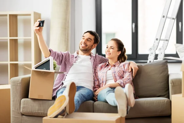 Pareja tomando selfie por smartphone en nuevo hogar —  Fotos de Stock