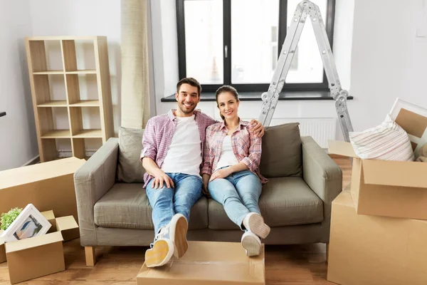 Feliz pareja con cajas mudándose a un nuevo hogar — Foto de Stock