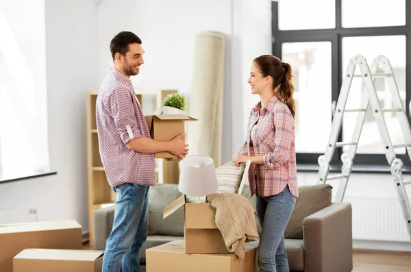 Happy couple with stuff moving to new home — Stock Photo, Image