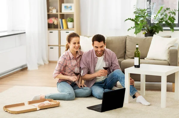 Coppia felice con il computer portatile bere vino rosso a casa — Foto Stock