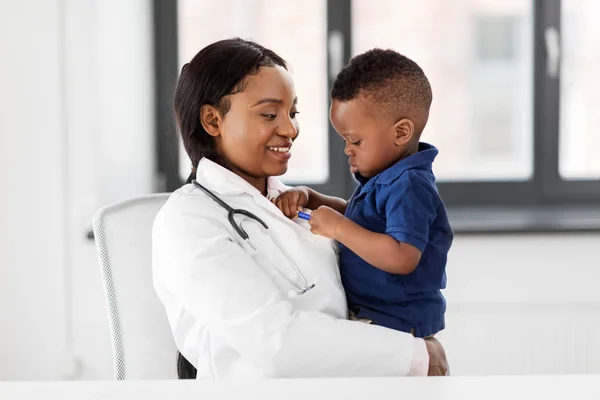 Médico o pediatra con bebé paciente en la clínica — Foto de Stock