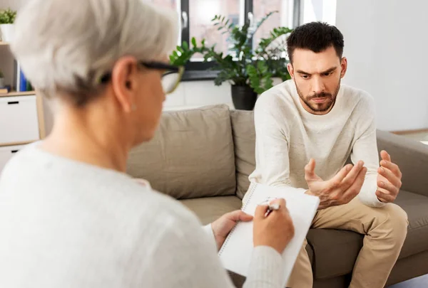 Senior vrouw psycholoog en trieste man patiënt — Stockfoto