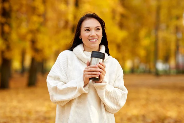 Femme avec boisson chaude dans tumbler au parc d'automne — Photo