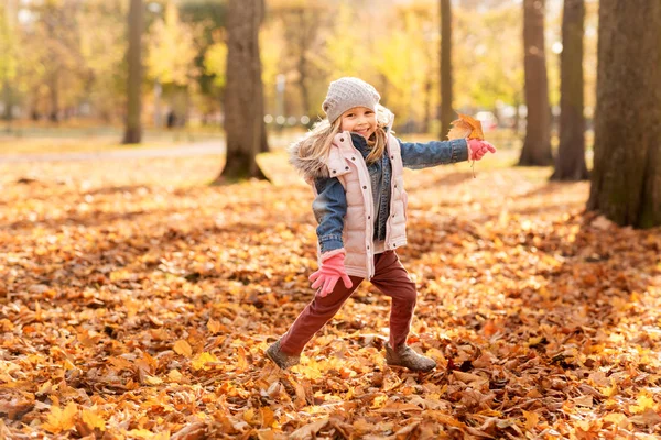 Gelukkig meisje rennen met Maple Leaf in Autumn Park — Stockfoto