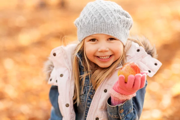 Bambina felice con mela al parco autunnale — Foto Stock