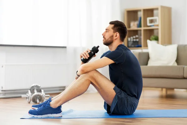 Hombre beber agua durante el entrenamiento en casa —  Fotos de Stock