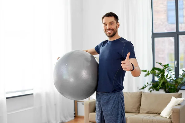 Hombre haciendo ejercicio con pelota de fitness en casa —  Fotos de Stock