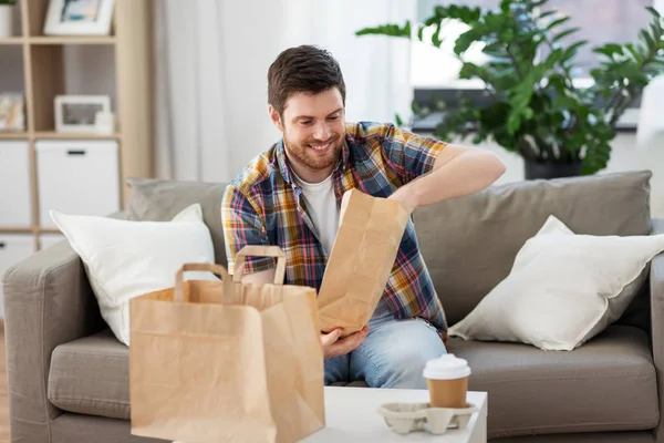 Lachende man uitpakken afhaalmaaltijden thuis — Stockfoto