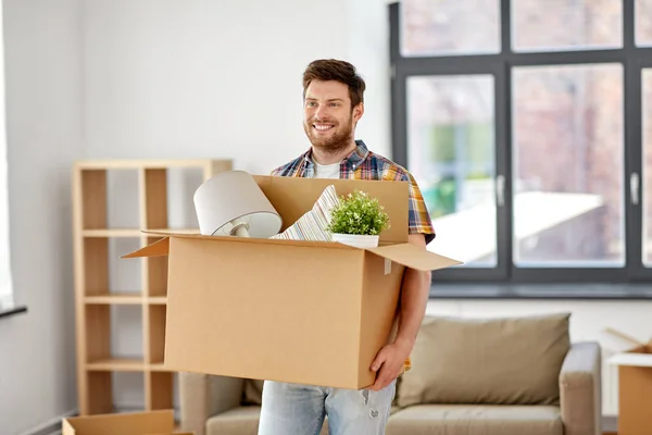 Счастливый человек с коробкой переезжает в новый дом — стоковое фото